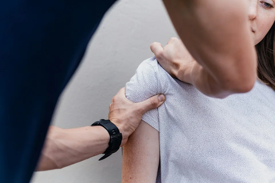 Osteopata che esegue una valutazione posturale in piedi